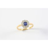 A SAPPHIRE AND DIAMOND CLUSTER RING the circular-cut sapphire is set within a surround of ten