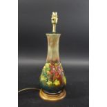MOORCROFT FLAMBE LAMP in the Columbine design, mounted on an oak base. With a Moorcroft shade.