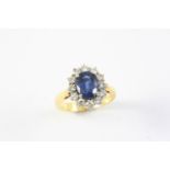 A SAPPHIRE AND DIAMOND CLUSTER RING the oval-shaped sapphire is set within a surround of twelve