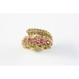 A RUBY AND DIAMOND CROSS-OVER RING BY LALAOUNIS set with seven graduated rubies and overall with