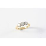 A DIAMOND THREE STONE RING the three graduated circular-cut diamonds are set in yellow gold. Size K