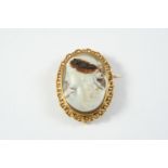 A FRENCH CARVED HARDSTONE CAMEO BROOCH depicting a classical woman as Flora, in ornate gold frame,