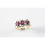 A RUBY AND DIAMOND TRIPLE CLUSTER RING the three oval-shaped rubies are each set within a surround