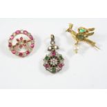 A GOLD AND GEM SET BIRD BROOCH mounted with two emeralds and suspending an untested pearl drop,