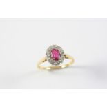A RUBY AND DIAMOND CLUSTER RING the oval-shaped ruby is set within a surround of circular-cut