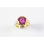 A RUBY AND DIAMOND RING the oval-shaped ruby is mounted in yellow gold, with two diamonds set to