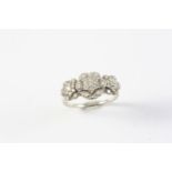 A DIAMOND TRIPLE CLUSTER RING set overall with circular-cut diamonds, in white gold. Size N