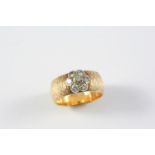 A DIAMOND AND GOLD RING the textured 18ct gold band is mounted with a diamond flowerhead cluster,