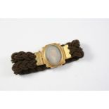 A VICTORIAN GOLD AND HAIR WORK MOURNING BRACELET centred with a gold mounted portrait of the head