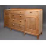 COTSWOLD SCHOOL SIDEBOARD - P HENSMAN an oak sideboard with a slightly curved front, with four