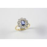 A SAPPHIRE AND DIAMOND CLUSTER RING the oval-shaped sapphire is set within a surround of circular-