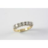 A DIAMOND HALF HOOP RING set with seven brilliant-cut diamonds in 18ct gold. Size P 1/2