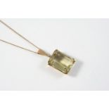 A CITRINE SINGLE STONE PENDANT the rectangular-shaped citrine is set in a 9ct gold mount, on a