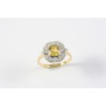 A YELLOW SAPPHIRE AND DIAMOND CLUSTER RING the oval-shaped yellow sapphire is set within a