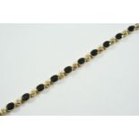 A SAPPHIRE AND DIAMOND BRACELET formed alternately with oval-shaped sapphires and circular-cut