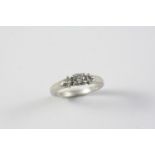 A DIAMOND THREE STONE RING set with three graduated circular-cut diamonds in platinum. Size L