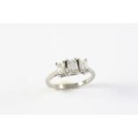 A DIAMOND THREE STONE RING the three graduated emerald-cut diamonds are set in platinum. Size M 1/2