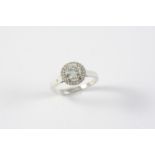 A DIAMOND CLUSTER RING the circular-cut diamond is set within a surround of circular-cut diamonds in