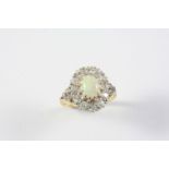 AN OPAL AND DIAMOND CLUSTER RING the oval-shaped solid white opal is set within a surround of