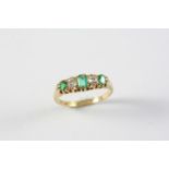 AN EMERALD AND DIAMOND FIVE STONE RING the three rectangular-shaped emeralds are set with two