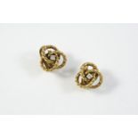 A PAIR OF DIAMOND AND GOLD CLIP EARRINGS each earring of swirl design and centred with a circular-