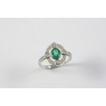 AN EMERALD AND DIAMOND CLUSTER RING the oval-shaped emerald is set within a surround of four