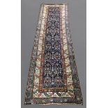 NARROW NORTH WEST PERSIAN RUNNER, CIRCA 1900 The indigo field with columns of stylised plants