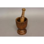 AN 18TH CENTURY OAK MORTAR AND YEW WOOD PESTLE. The mortar of turned form with ring turned
