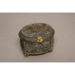 A CONTINENTAL COPPER AND GILT JEWELLERY BOX. An oval box, all over decorated in relief with scenes