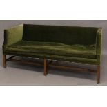 A GEORGE III MAHOGANY FRAMED LOW BACKED SETTEE. The settee upholstered in green velvet, with low
