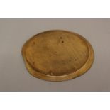 A 19TH CENTURY PLATTER. A circular wooden platter or bread board with tapering rim and signs of much
