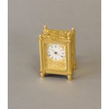 A MINIATURE BRASS CASED CARRIAGE CLOCK BY HOWELL JAMES AND Co. With a circualr white enamelled