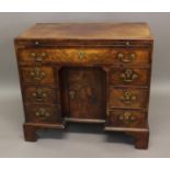 A GEORGE III MAHOGANY KNEEHOLE DESK with frieze drawer below a slide, central recessed cupboard,