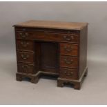 A GEORGE III MAHOGANY KNEE HOLE DESK. The rectangular top with a moulded border above a brushing