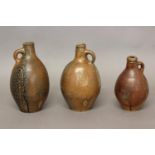 THREE SIMILAR 18TH CENTURY SALTGLAZED JUGS. Three stoneware narrow-necked stoneware jugs with narrow