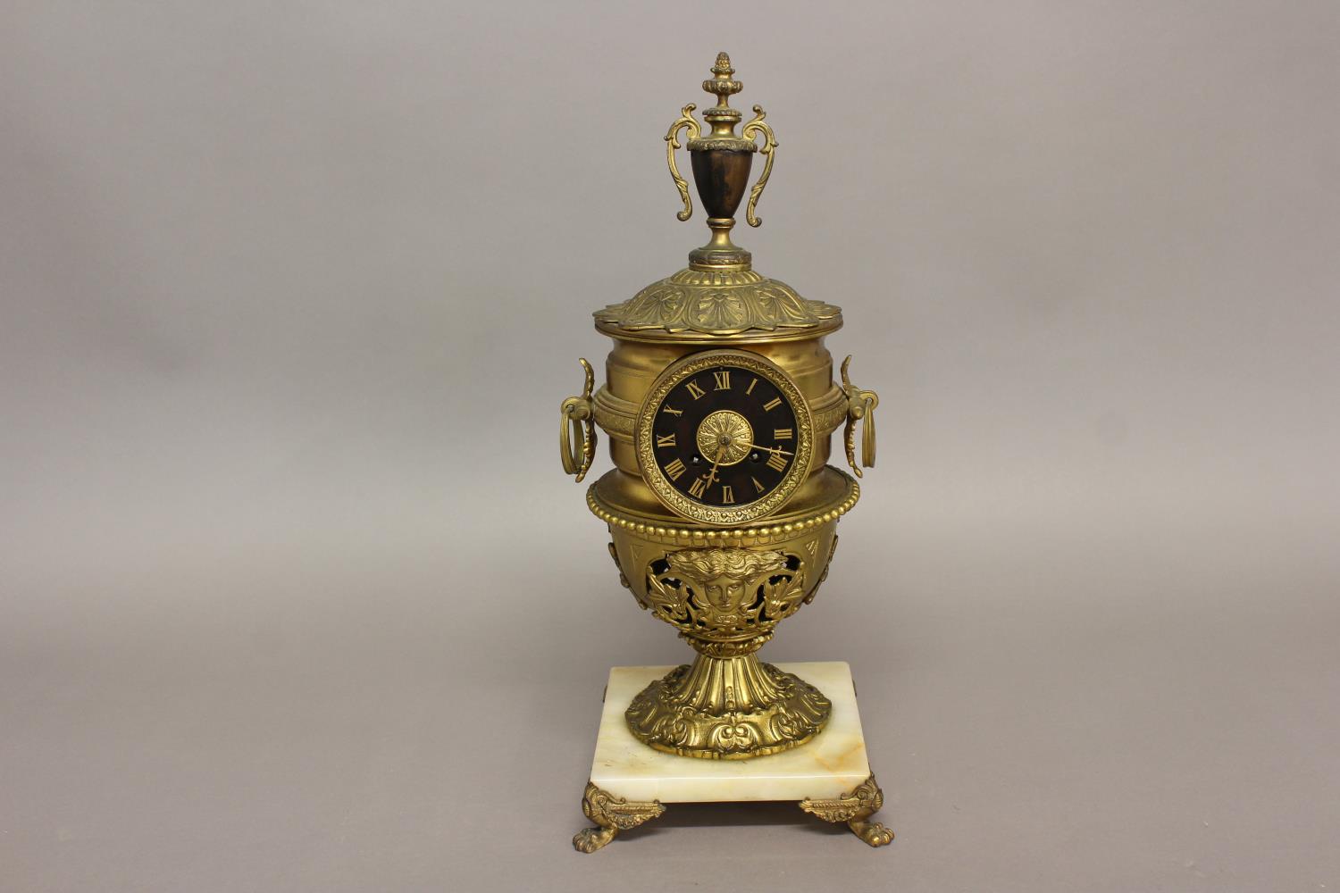 AN ELABORATE URN SHAPED MANTEL CLOCK. The clock with a black dial with gilt Roman numerals, with