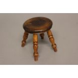 A 19TH CENTURY MINIATURE STOOL. The circular seat with turned edge on four turned legs, 13cm high,