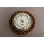AN OAK FRAMED BAROMETER BY ADIE OF WESTMINSTER. With a carved 'rope twist' surround and decorative