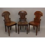 A SET OF THREE VICTORIAN MAHOGANY HALL CHAIRS. Each with moulded backs with scrolling top rails