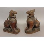 A PAIR OF CHINESE CARVED WOODEN TEMPLE GUARDIANS. In the form of mythical beasts with dragons heads,