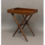 A VICTORIAN MAHOGANY BUTLERS TRAY AND STAND. The rectangular tray with raised border and twin