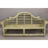 A WOODEN GARDEN BENCH IN THE MANNER OF LUTYENS. With an arched back above a slatted seat with