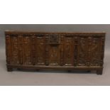 A MEDIEVAL STYLE OAK COFFER FRONT. With seven tall rectangular panels carved with stylised faces