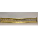 A VICTORIAN POLISHED BRASS SERPENTINE FRONTED FENDER. The serpentine front with a rounded top