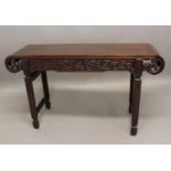 A CHINESE HARDWOOD ALTAR TABLE the rectangular top with scrolled ends and the frieze carved on