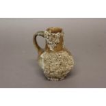 A STONEWARE 'SHIP WRECK' JUG. A salt glazed stoneware jug with straight sided neck, scrolling handle