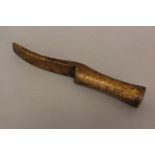 AN UNUSUAL 19TH CENTURY TOOL. The hand held took with a curving blade like end and turned grip, with