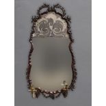 A WALL MIRROR OF 18TH CENTURY ITALIAN DESIGN with carved frame, engraved mirror plate and two candle