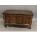 A 17TH CENTURY OAK COFFER. The rising top with four panels above a four panel front with geometric