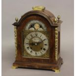 A GEORGE II STYLE WALNUT CASED BRACKET CLOCK. The arched dial with moon phase above a silvered